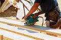 Carpenter using circular saw for cutting wooden boards. Construction details of male worker Royalty Free Stock Photo