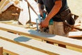 Carpenter using circular saw for cutting wooden boards. Construction details of male worker or handy man Royalty Free Stock Photo