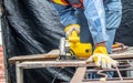 Carpenter using circular saw for cutting wooden boards with power tools, construction and home renovation, repair and construction Royalty Free Stock Photo