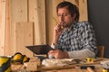 Carpenter using digital tablet in small business woodwork workshop