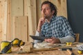 Carpenter using digital tablet in small business woodwork workshop