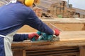 Carpenter using electric planer with wooden plank in carpentry workshop Royalty Free Stock Photo