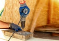 Carpenter using an electric screwdriver screwing wood screw into wood, Install and repair structures fixtures made from wood