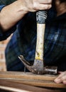 Carpenter using hammer pull a nail out from a wood