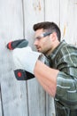 Carpenter using hand drill on wooden cabin Royalty Free Stock Photo