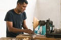 carpenter using his tools to make pieces of wood.Enterprising man doing his daily trades