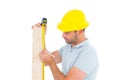 Carpenter using measure tape to mark on wooden plank Royalty Free Stock Photo