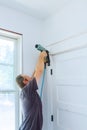 Carpenter using nail gun to moldings on door, framing trim, Royalty Free Stock Photo