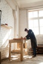 Carpenter using power hand saw cutting wooden planks in workshop Royalty Free Stock Photo