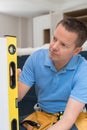 Carpenter Using Spirit Level Installing Luxury Fitted Kitchen Royalty Free Stock Photo
