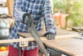 A carpenter ware gloves use hand saw to sawing wood Royalty Free Stock Photo