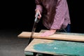 Carpenter woman sawing a board with a hand wood saw. Carpentry, construction, woodworking concept