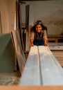Carpenter woman stand in line of timber and look at camera with smiling in concept of happiness woodwork in own business