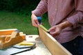 Carpenter woman using a measuring tape for check the length of timber plank. Woodworking concept Royalty Free Stock Photo