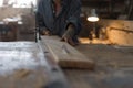 Carpenter woman works on a saw, sawing a wooden product. Royalty Free Stock Photo