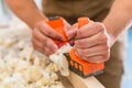 Carpenter with wood planer working on piece