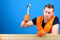 Carpenter, woodworker on busy face hammering nail into wooden board. Building and construction concept. Man, labourer Royalty Free Stock Photo