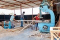 Carpenter woodworkers cutting a timber with band saw machine in a carpentry workshop