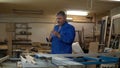 Carpenter at work at his workshop, wood processing on a woodworking machine