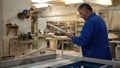 Carpenter at work at his workshop, wood processing on a woodworking machine