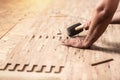 Carpenter on work laying laminate or parquet flooring use a rubber mallet, applied adhesive for parquet. Home renovation, Close up