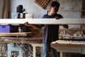 Carpenter at work sanding the wood with sanding machine blurry background. r Royalty Free Stock Photo