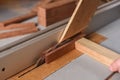 Carpenter working with circular saw helping with stick for safety Royalty Free Stock Photo