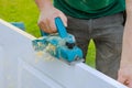 Carpenter working with electric planer on wooden door in outdoor Royalty Free Stock Photo