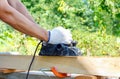 Carpenter working with electric planer on wooden plank Royalty Free Stock Photo