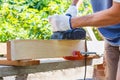 Carpenter working with electric planer on wooden plank Royalty Free Stock Photo