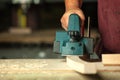 Carpenter working with electric planer. Royalty Free Stock Photo