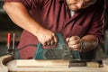 Carpenter working with electric planer. Royalty Free Stock Photo