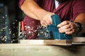 Carpenter working with electric planer. Royalty Free Stock Photo