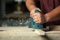 Carpenter working with electric planer.