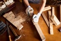 Female Apprentice Planing Wood In Carpentry Workshop. Carpenter woman working with plane. Royalty Free Stock Photo