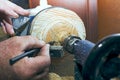 Carpenter working on a lathe on wood. A man`s hand with a pencil draws marks on the product