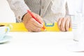 Carpenter working with level equipment and wood pencil in his hand on white table. Royalty Free Stock Photo