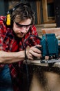 Carpenter working of manual hand milling machine in the carpentry workshop. joiner.