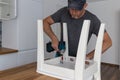 Carpenter working on new kitchen. Handyman fixing a chair with screwdriver Royalty Free Stock Photo