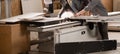 Carpenter working with panel saw and sawing fiberboard at furniture factory. Production, manufacture and woodworking Royalty Free Stock Photo