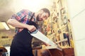 Carpenter working with saw and wood at workshop Royalty Free Stock Photo