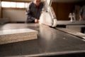 Carpenter working with sliding panel saw and sawing mdf board or fibreboard at furniture factory workshop. Manufacture Royalty Free Stock Photo