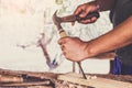 Carpenter working using a chisel is carving wood using a woodworking tool working in workshop Royalty Free Stock Photo