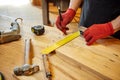 Carpenter working with a wood, marking plank with a pencil and taking measurements to cut a piece of wood to make a piece of Royalty Free Stock Photo