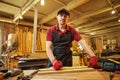 Carpenter working with a wood, marking plank with a pencil and taking measurements to cut a piece of wood to make a piece of Royalty Free Stock Photo