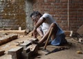 A carpenter working on wood by using traditional tools