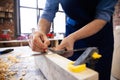 Carpenter working on woodworking machines in carpentry shop. A man works in a carpentry shop.