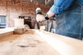 Carpenter working on woodworking machines in carpentry shop. A man works in a carpentry shop. Royalty Free Stock Photo