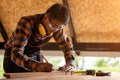 Carpenter working on woodworking machines in carpentry shop. man works in a carpentry shop using wearing protective headphones Royalty Free Stock Photo