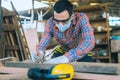 Carpenter is working in a woodworking office.caucasion white Carpenter using tape measure to measure distance and marking with